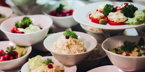 View of many round plates with tasty vegetables dish of salads with tomato, onion, zucchini, tomato and herbs. Big delicious for dinner in restaurant.